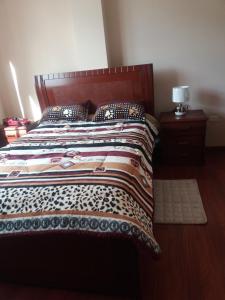 a bedroom with a bed with a quilt on it at Casa David in Riobamba