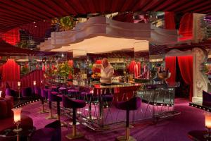 a man standing at a bar in a room with purple chairs at Ulysses in Baltimore