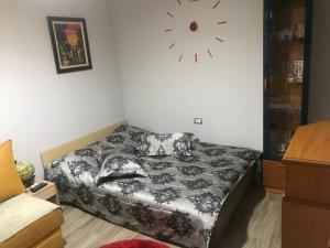 ein Schlafzimmer mit einem Bett und einer Uhr an der Wand in der Unterkunft JANO apartment Korce in Korçë