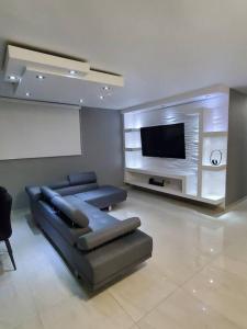 sala de estar con sofá y TV de pantalla plana en Luxury 3-bedrooms near airport in San Juan, en San Juan