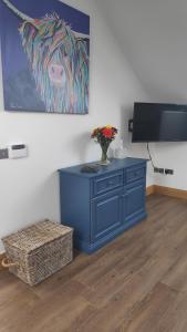 a blue cabinet with a vase on it in a room at The Cow Hide @ Mill Burn Hollow. in Millisle