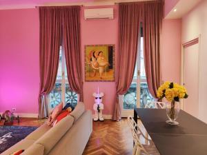a pink living room with a couch and a table at Designed Pop Apartment 2 Bedrooms, 2 Baths in Milan Center - WiFi, AC, steps from Subway M1 and M2, Central Station and Airport connected in Milan