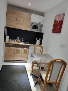 - une cuisine avec une table, des chaises et un évier dans l'établissement Apartment North City Hannover, à Hanovre