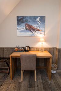 a desk in a room with a painting on the wall at La Barrière de Transinne in Libin