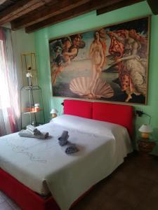 ein Schlafzimmer mit einem großen Gemälde über einem Bett in der Unterkunft Casa Giampy in Bergamo