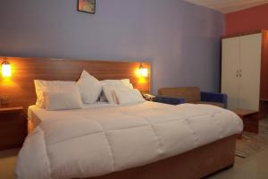 a large white bed in a hotel room at Dialali Hôtel Nouakchott in Nouakchott