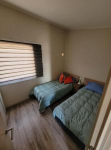 1 dormitorio con 2 camas y ventana en Hermosa casa en Bahía inglesa 3 habitaciones, en Bahía Inglesa