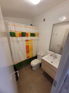 a bathroom with a rainbow shower curtain and a toilet at Hermosa casa en Bahía inglesa 3 habitaciones in Bahia Inglesa