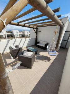 un patio con columpio y sillas en la azotea en Hermosa casa en Bahía inglesa 3 habitaciones, en Bahía Inglesa