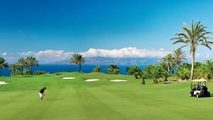 a man is playing golf on a golf course at Playa del Duque-Amazing views 2 bedroom in Adeje