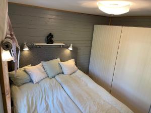 um quarto com uma cama com cabeceira em Cozy cabin, neighbour to lake & national park em Tyresö