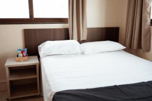 um quarto com 2 camas e uma janela em Paris Hotel by H Hotéis - Business em Taguatinga