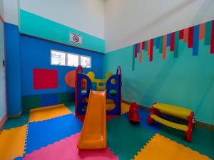 a childs play room with a slide and a playground at Praiamar Express Hotel in Natal