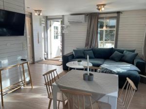 sala de estar con sofá azul y mesa en Cozy cabin, neighbour to lake & national park, en Tyresö