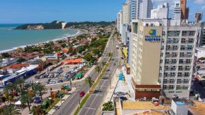 Praiamar Express Hotel في ناتال: اطلالة جوية على مدينة فيها شاطئ ومباني