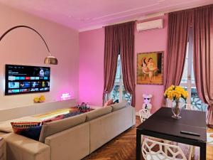 a living room with pink walls and a couch at Designed Pop Apartment 2 Bedrooms, 2 Baths in Milan Center - WiFi, AC, steps from Subway M1 and M2, Central Station and Airport connected in Milan