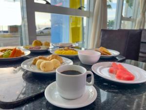 a table with plates of food and a cup of coffee at Praiamar Ponta Negra Hotel in Natal +41 photos