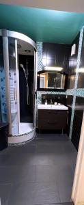 La salle de bains est pourvue d'une baignoire, d'un lavabo et d'un miroir. dans l'établissement Le jardin du stade by UTA HOUSE, à Saint-Denis