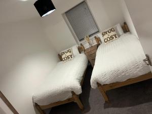 two twin beds in a room with white walls at 2 bed hengrove in Brislington