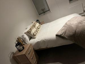 a bed with white sheets and pillows and a night stand at 2 bed hengrove in Brislington