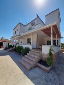 a white house with stairs in front of it at Villa Shehu in Ksamil