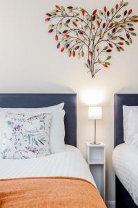 a bedroom with a heart wall art above a bed at MPL Apartments - Queens Broadway F3 in Watford