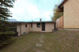 a house with a yard next to a building at Pavillon douillet avec vue sur lac in Chorges