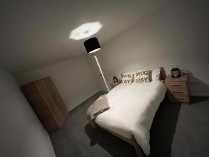 a bedroom with a bed with white sheets and a lamp at 2 bed hengrove in Brislington