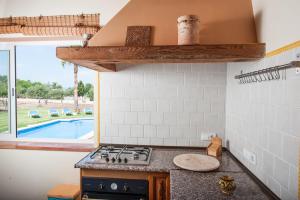 cocina con fogones horno de arriba junto a una piscina en Ca Na Granada, en Muro