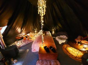 una camera con letto e lampadario a braccio in una tenda di Glamping in - luxury tent 