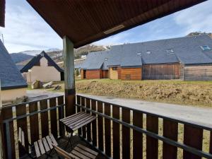 une terrasse couverte en bois avec un banc sur une maison dans l'établissement Val Louron Hautes Pyrénées Superbe appartement tout confort au pied des pistes 4 personnes, à Val Louron