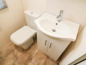 Un baño con un lavabo blanco y un inodoro. en 3 Yealands, en Carnforth 14 fotos más