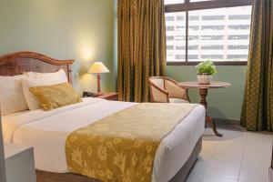 a hotel room with a bed and a table and a window at Hotel Faranda Express Puerta Del Sol Barranquilla, A Member of Radisson Individuals in Barranquilla