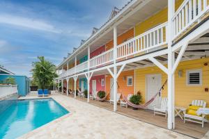 a hotel room with a pool and a balcony at Bed & Bike Curacao - Jan Thiel in Willemstad