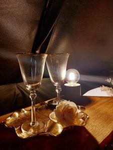 due bicchieri di vino e un fiore sul tavolo di Glamping in - luxury tent 