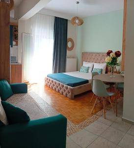 een slaapkamer met een bed, een tafel en een bank bij DREAM HOME in Larisa