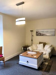 een woonkamer met een bank en een salontafel bij City living maisonette, The Nest in Swansea