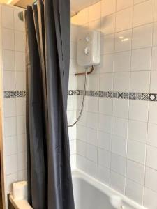 een badkamer met een douche met een zwart douchegordijn bij City living maisonette, The Nest in Swansea
