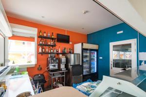 a kitchen with an orange and blue wall at Bed & Bike Curacao - Jan Thiel in Willemstad