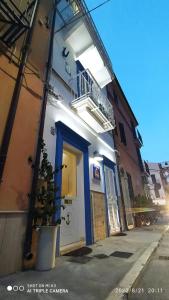 a white building with a blue door and a balcony at Acasadelpescatore in San Benedetto del Tronto