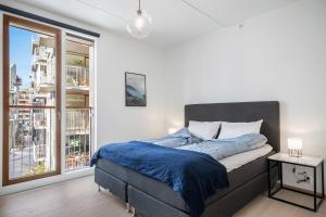 a bedroom with a bed and a large window at Amazing luxury apartment on the waterfront! 73sqm in Oslo