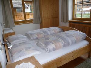 a bed with pillows on it in a room at Haus am Park in Rasùn di Sotto