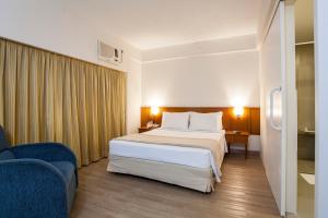 a hotel room with a bed and a blue chair at Travel Inn Hotels Ibirapuera in Sao Paulo +33 photos
