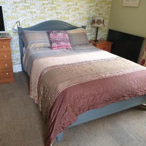 a bedroom with a bed and a night stand with a lamp at The Cabin: Great Views,Garden,Close to Town, Quiet in Hebden Bridge