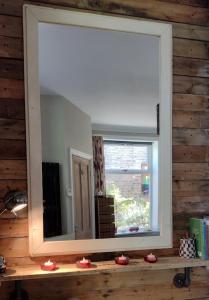 um espelho numa parede de madeira com uma janela em The Cabin: Great Views,Garden,Close to Town, Quiet em Hebden Bridge