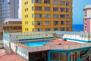 a large yellow building with a swimming pool next to a building at 10South in Durban