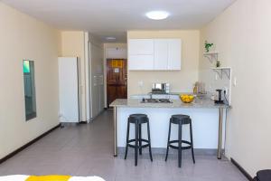 a kitchen with two bar stools at a kitchen counter at 10South in Durban