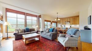 ein Wohnzimmer mit 2 Stühlen und einem Tisch in der Unterkunft Beautiful Golf Course Setting by Harmony Whistler in Whistler