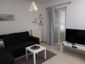 sala de estar con sofá, TV y mesa en Apartman Felice, en Kraljevica