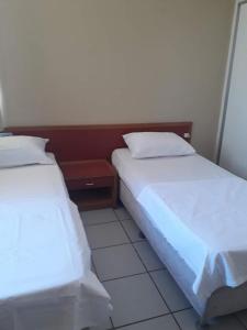 two beds sitting next to each other in a room at Ocean Tower Fortaleza in Fortaleza